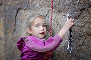 Extreme sport, active lifestyle, kid with a rope engaged in the sports of rock climbing on the rock