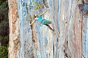Extreme Sport Athlete hanging on vertical natural Wall photo