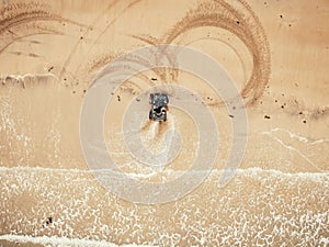 Extreme sport on quad bike beach of sea leaves traces. Aerial top view