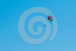 Extreme sports and exciting rest. Tourist fly on a parashute in the blue sky background