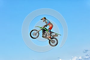 Extreme sports, motorcycle jumping. Motorcyclist makes an extreme jump against the sky.