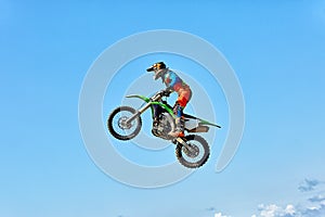 Extreme sports, motorcycle jumping. Motorcyclist makes an extreme jump against the sky. photo