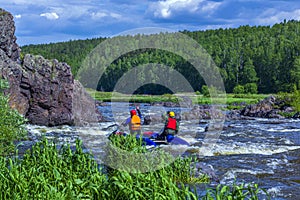 Extreme whitewater rafting trip. A group of people team in sport ÃÂatamarans practise traversing the water rapids of the