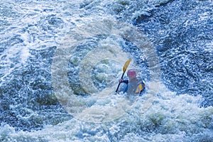 Extreme whitewater rafting trip. A one person in kayak practise traversing the water rapids. Kayaker paddling on the mountain