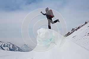Extreme winter sports: climber reaches the top of a snowy peak in the Alps. Concepts: determination, success, strength.