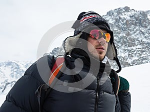 Extreme winter sports: climber reaches the top of a snowy peak in the Alps. Concepts: determination, success, strength.