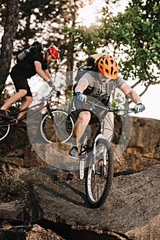 extreme young trial bikers riding on rocks