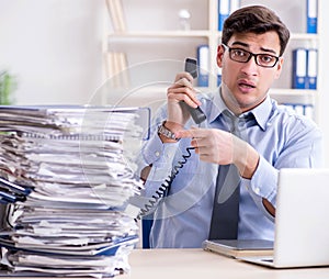 Extremely busy businessman working in office