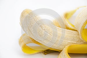 Extremely closeup of a tasty peeled banana fruit over white background