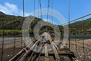 Extremely dilapidated suspension bridge only provisionally repaired, dangerous bridge in Albania, Balkan