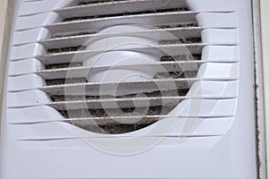 Extremely dirty and dusty white plastic ventilation air grille at home close up, harmful for health, house cleaning concept