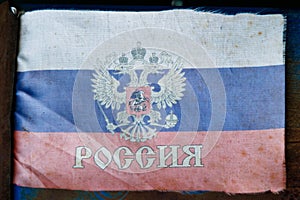 extremely faded small fabric russian flag with with coat of arms