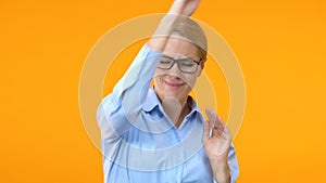 Extremely glad business woman dancing against orange background, promotion