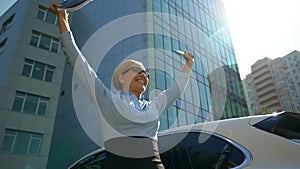 Extremely happy lady rising her hands up rejoicing to successful contract