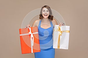 Extremely happy positive woman standing with two shopping bags, being glad to do shopping.