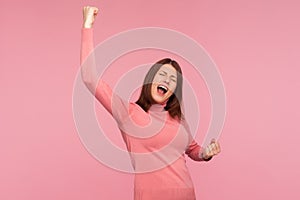 Extremely happy satisfied woman showing yes gesture and screaming celebrating her victory, success, dreams comes true, euphoria