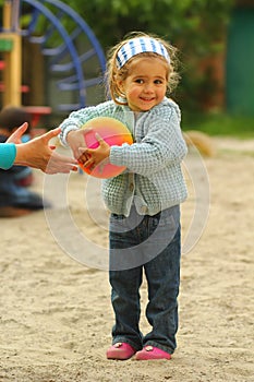 Extremely happy toddler girl who at last has caught the ball