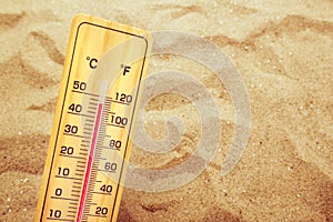 Extremely high temperatures, thermometer on warm desert sand photo