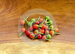 Extremely hot chilli pepper on a wooden background .
