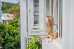 Extremly tired woman looking out the window, home alone. self-isolation at home, quarantine due to pandemic COVID 19