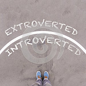 Extroverted vs Introverted text on asphalt ground, feet and shoe