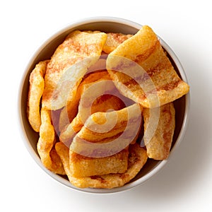 Extruded bacon flavoured chips in white ceramic dish isolated on