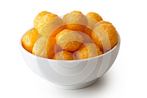 Extruded puffed cheese balls in white ceramic dish isolated on w