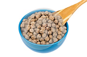 Extruded rye bran in blue bowl and bamboo spoon