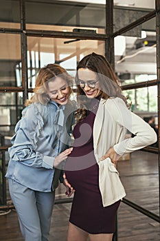 Exuberant colleague encouraging pregnant woman