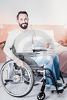 Exuberant crippled man holding a tablet