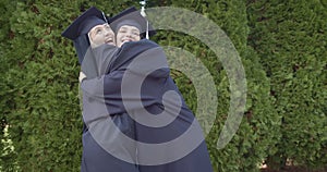 Exuberant graduates, reveling in their achievement, toss their mortarboards into the air outdoors, capturing the sheer