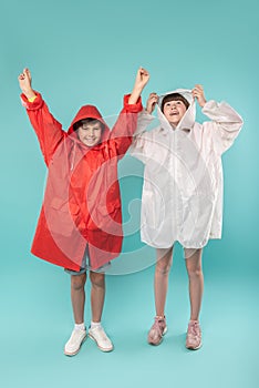 Exuberant kids wearing lovely raincoats