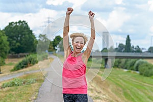 Exuberant vivacious woman celebrating outdoors photo