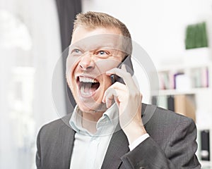 Exuberant young man shouting in reaction to a call