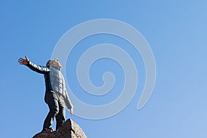 Exuberant young man on top of an old stone wall