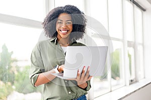 An exuberant young professional woman engages with her laptop photo