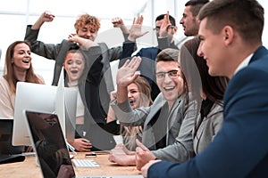 Exultant business team looking at the screen of the office computer
