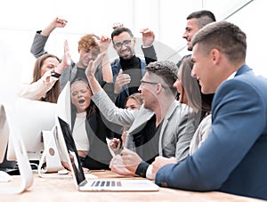 Exultant business team looking at the screen of the office computer