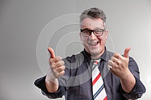 Exultant businessman giving a double thumbs up