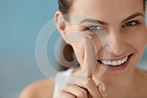 Eye care. Smiling woman with contact eye lens on finger closeup