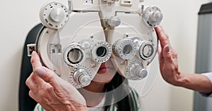 Eye care, tools and child in clinic, test and hand of specialist, phoropter or refractor for girl. Healthcare