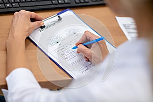 Eye doctor making notes after making astigmatism test for patient