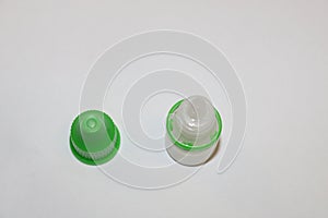 Eye drops bottle with open green cap. Eye drop bottle. Ear drop bottle.