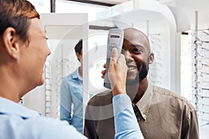 Eye exam, eyewear and an optometrist checking happy young male eyes with optic medical equipment. African man getting