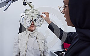 Eye exam, vision and woman with Muslim optometrist in clinic for test, eyesight and optical assessment. Optometry