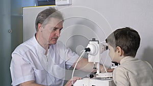 Eye examination, optometrist in exam room with young boy