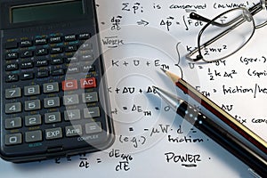 Eye Glasses, pen and pencil over the Formula with calculator