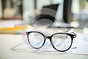 eye glasses placed on the desk are eye glasses that are prepared for people with farsightedness to work and read documents clearly