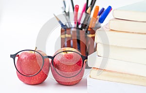 Eye glasses and red apple with book and stationery Supplies and accessories on white background.Back to school.Education concept