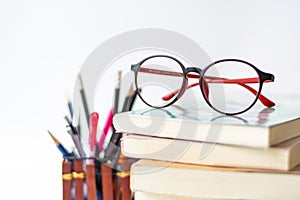 Eye glasses and red apple with book and stationery Supplies and accessories on white background.Back to school.Education concept